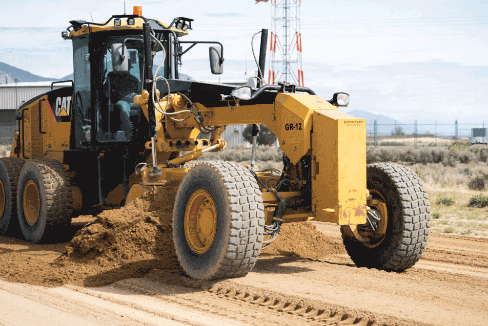 Motor grader operator smoothing a road surface