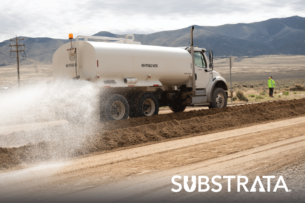 Water truck applying Perma-Zyme to an unpaved dirt road