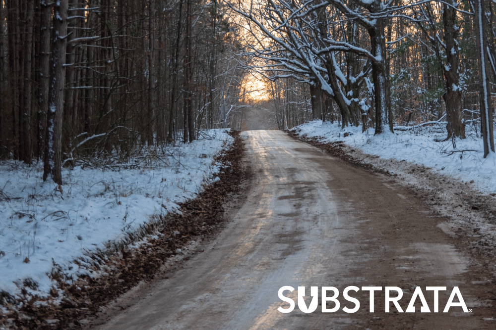 Snowy unpaved road needing stabilization