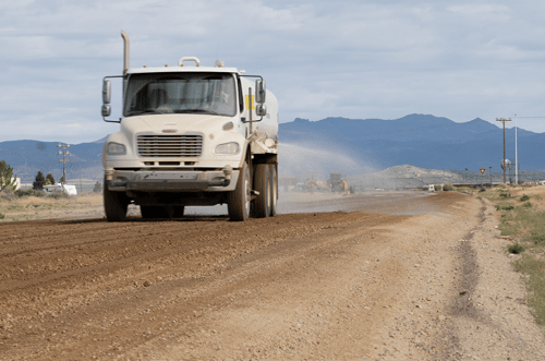 Perma-Zyme being sprayed onto subgrade with a water truck 