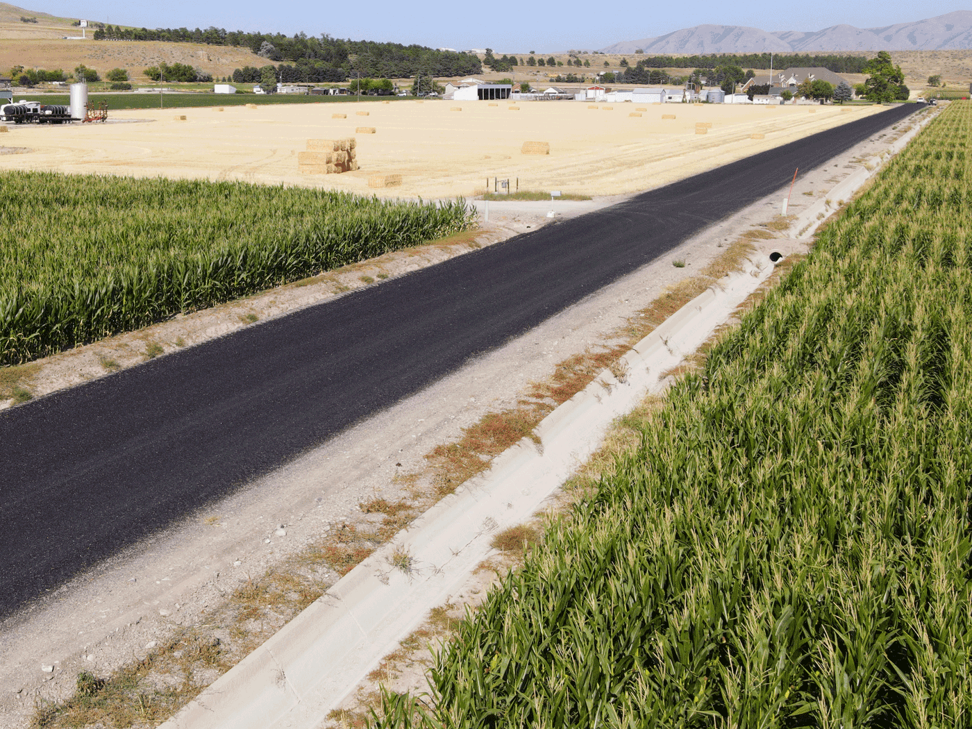 Side view of Box Elder County road showing drainage ditches and road condition with Perma-Zyme and chipseal treatment