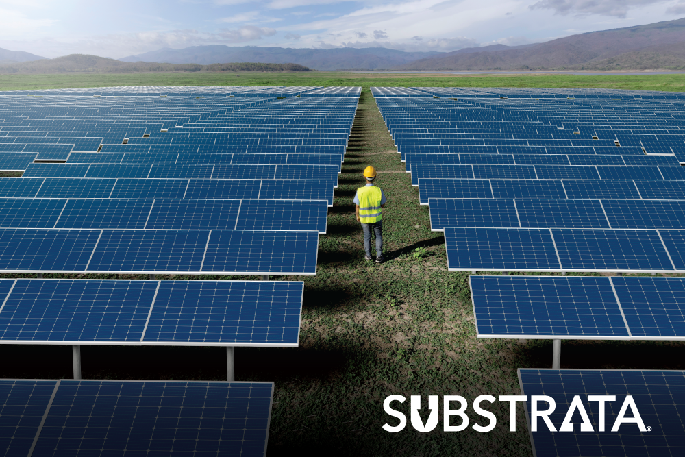 Solar farm maintenance worker walking between rows of panels