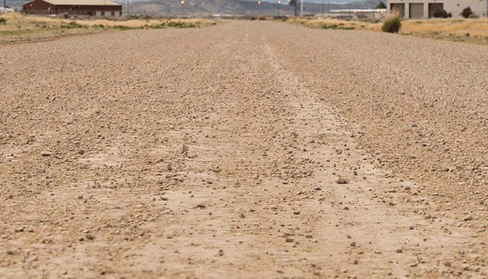 Close-up of Perma-Zyme treated dirt road stretching into the distance in the American southwest