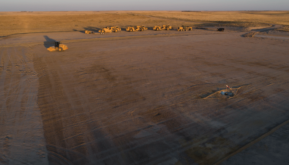 Aerial photo of heavy equipment on an unpaved, dirt surface treated with Perma-Zyme